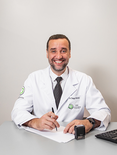 Dr. Thiago em sua mesa de consulta